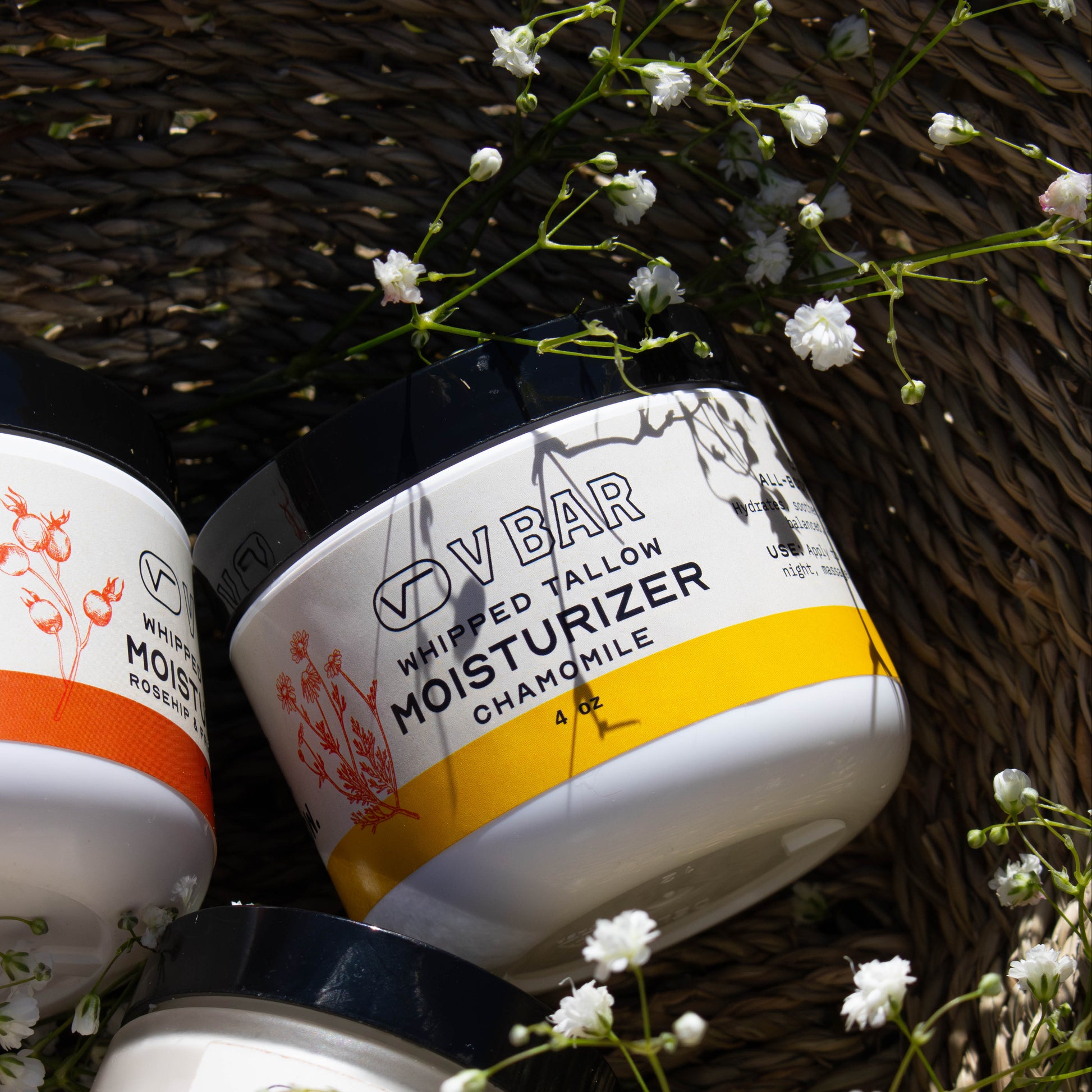 Whipped tallow moisturizer made from grass-fed beef suet sourced from Montana ranches laying in a basket of flowers