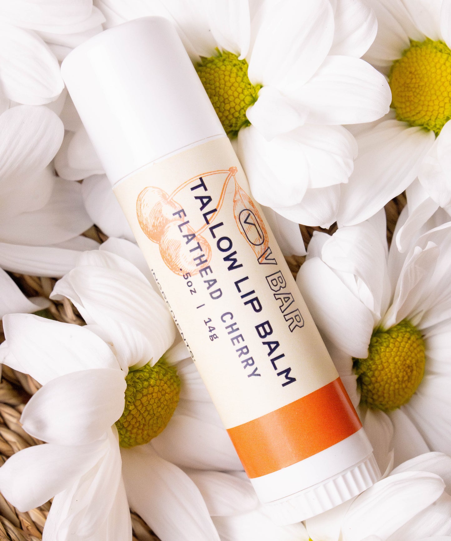 Natural tallow lip balm made from grass-fed beef suet for dry lips and sourced from Montana ranches laying on a bed of flowers